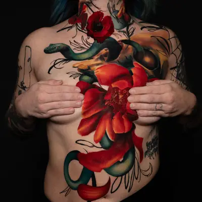 Tattoo of a green snake entwined with red flowers on chest and neck.