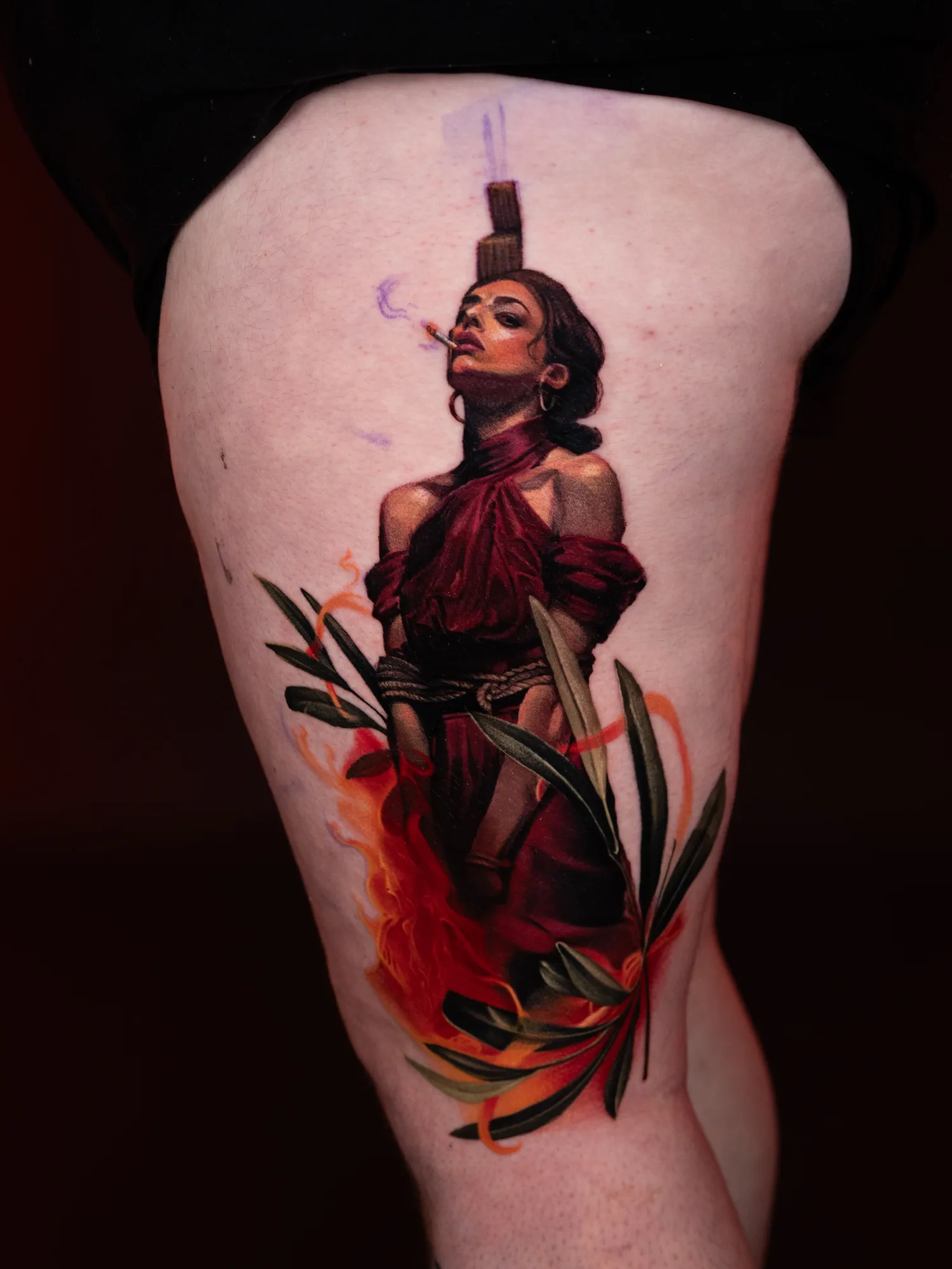 Tattoo of a woman bound with ropes, burning on a stake.
