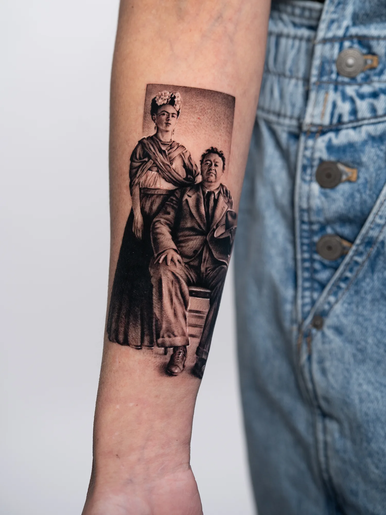 Portrait tattoo of Frida Khalo and Diego Rivera set on an inner forearm.