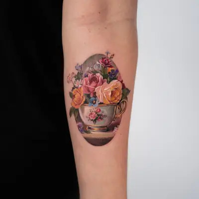Tattoo of a still life painting with roses in a teacup.