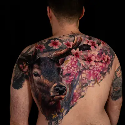 Tattoo of a deer and cherry blossoms on a man's back.