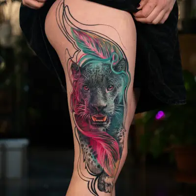 Colorful panther tattoo on leg with feather accents.