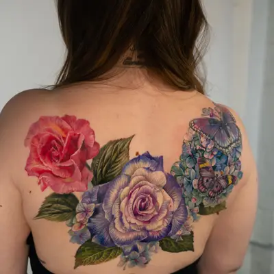 Back tattoo of colorful roses and butterflies.