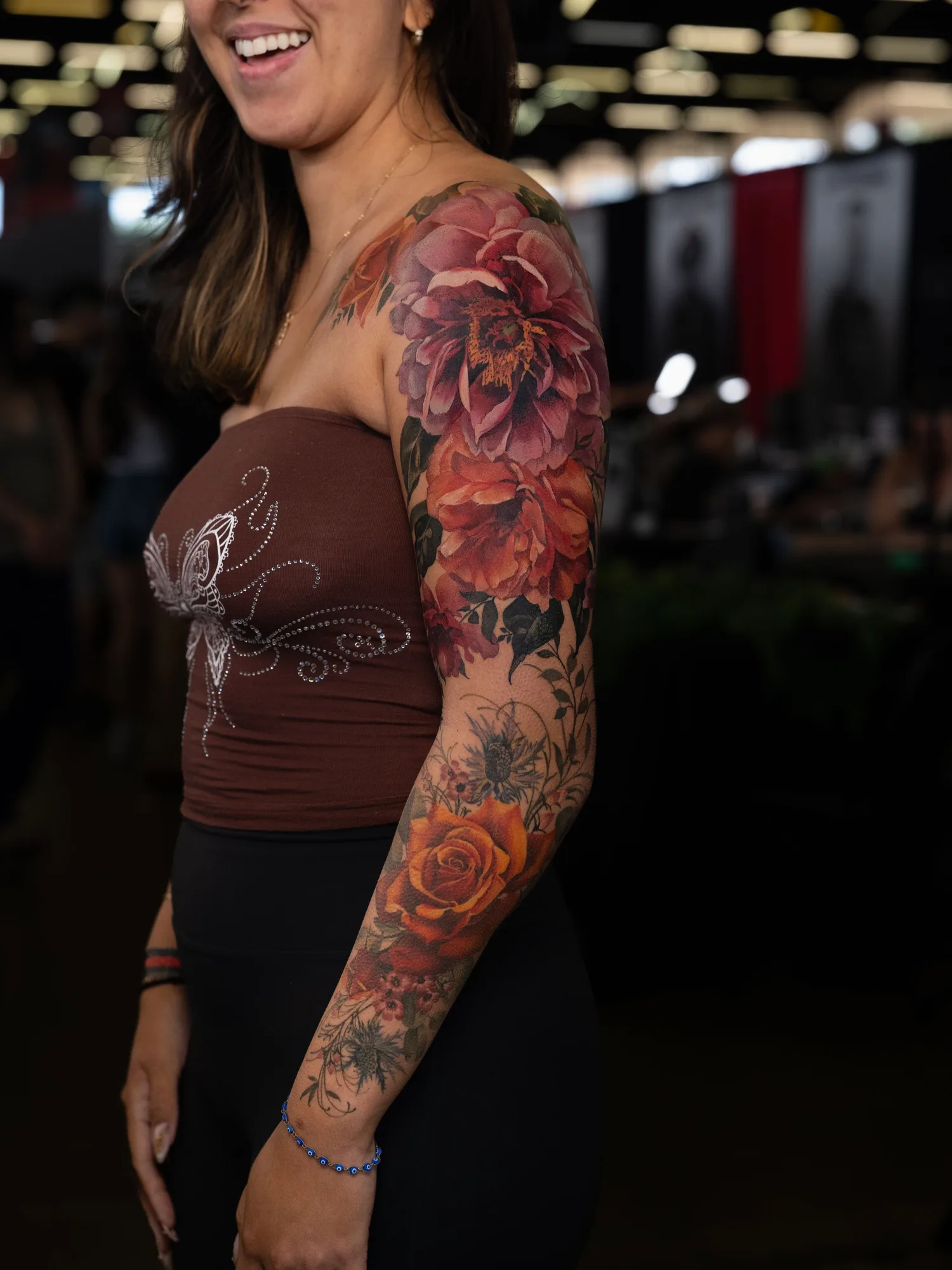 A vibrant floral tattoo covering a woman's arm with bold colors and intricate details.