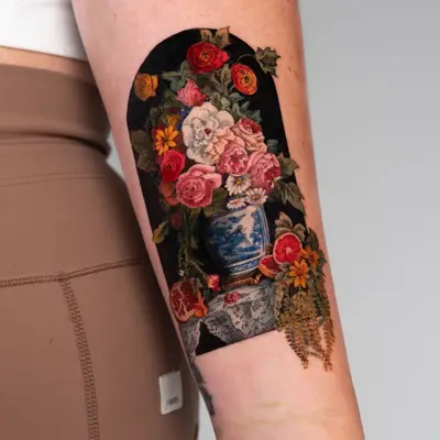 A colorful floral tattoo of a Dutch floral painting on the inner forearm featuring a vase and intricate flowers.