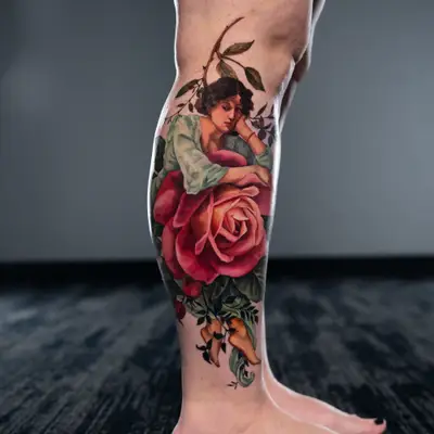 Tattoo of a lady resting on a flower on the lower leg in a painterly style.