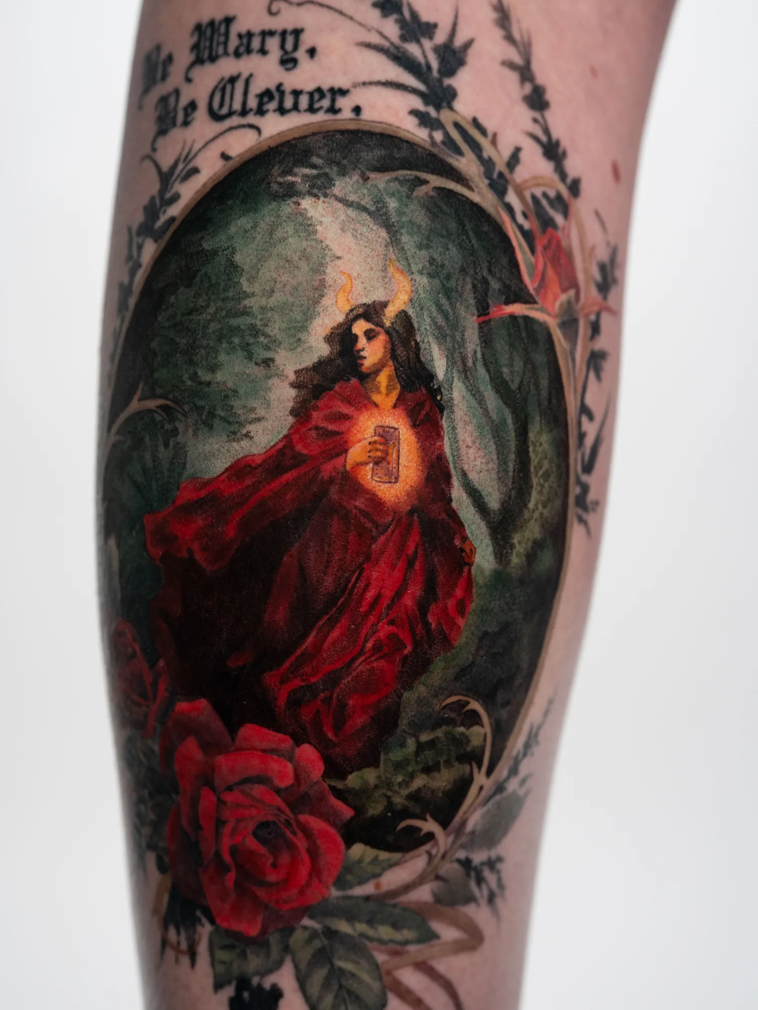 Dark fantasy romance tattoo of a woman in a dark forest in color on a thigh.