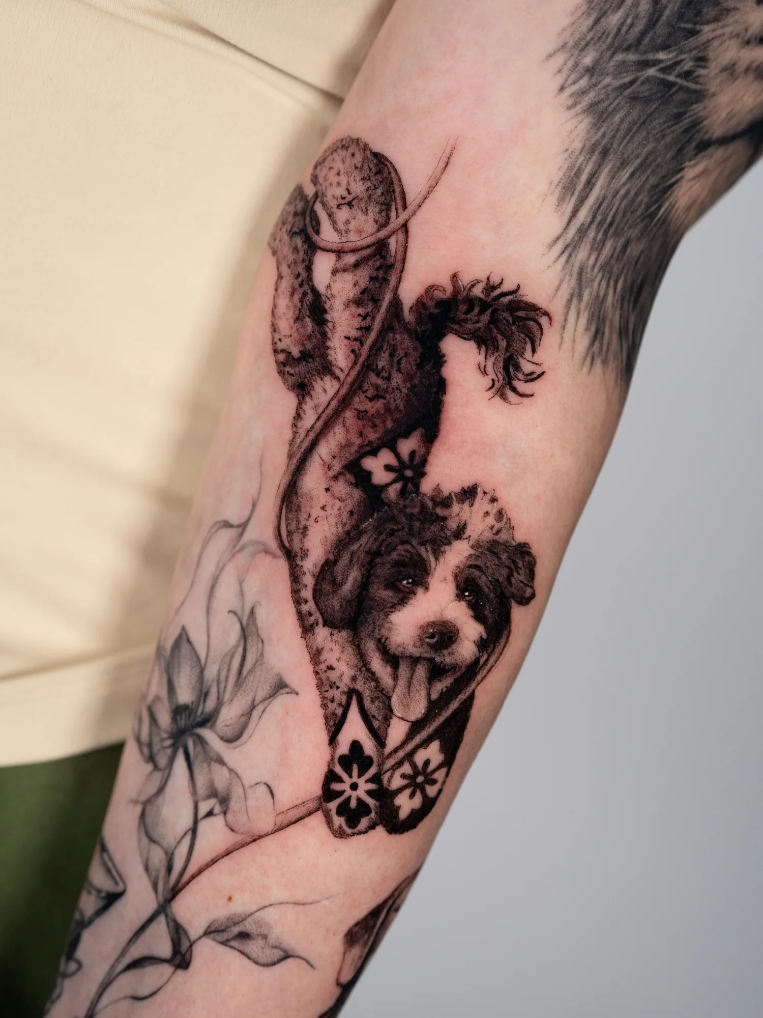 Realistic dog tattoo with geometric elements on inner forearm.