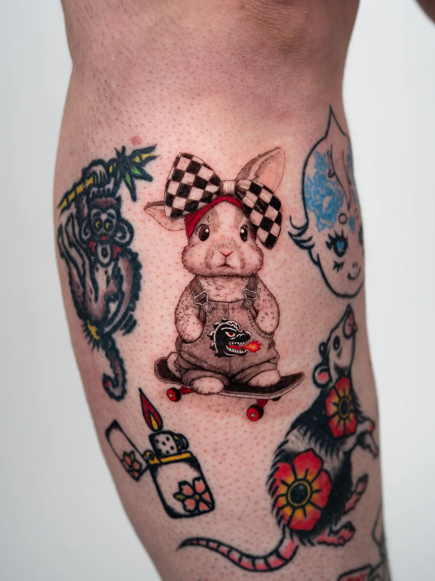 Micorealism tattoo of a bunny riding a skateboard on a lower leg.