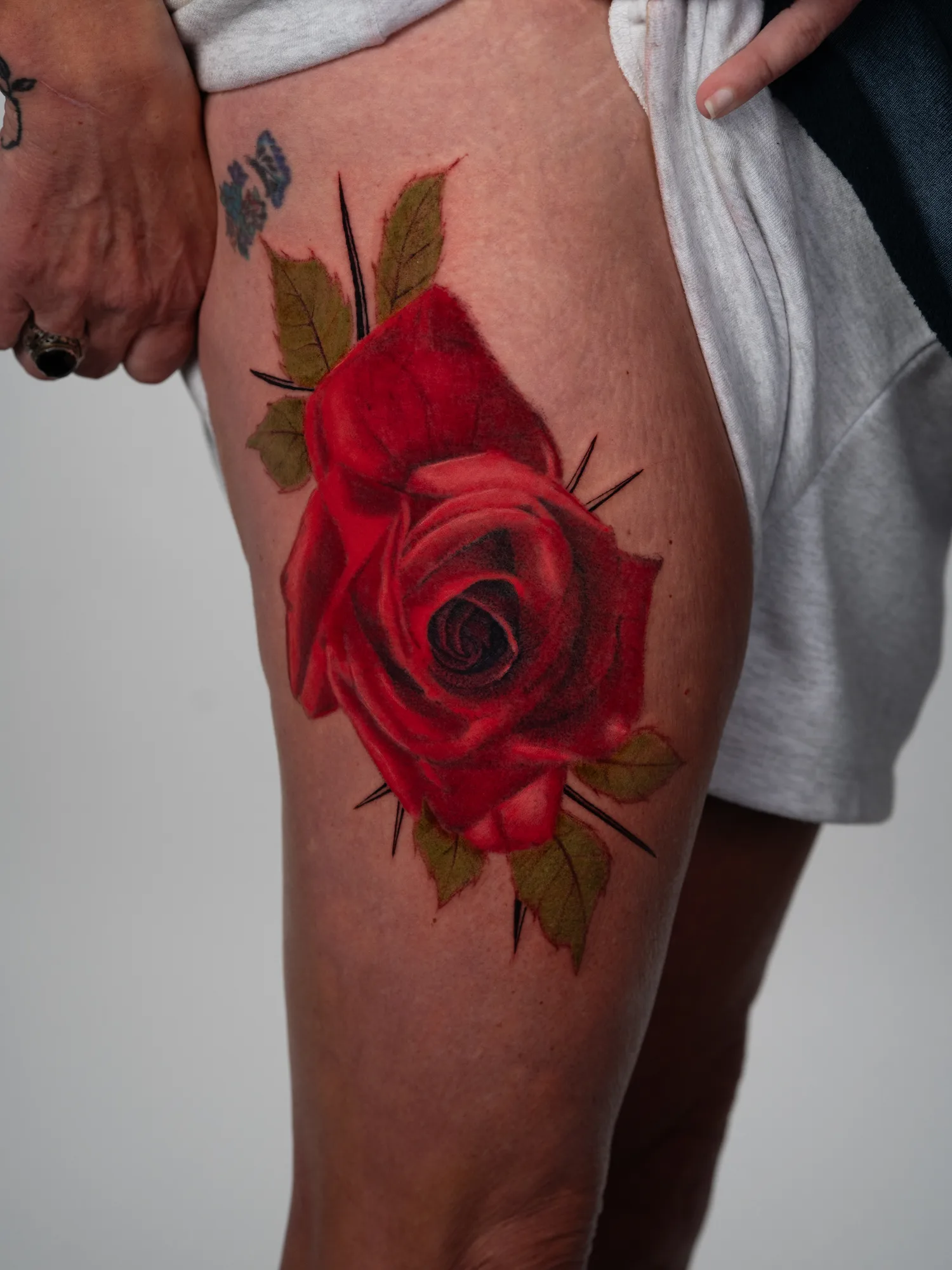 Large color realism red rose on the thigh.