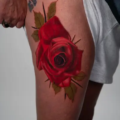 Large color realism red rose on the thigh.