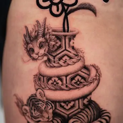 A tattoo featuring a flower pot, a cat with horns, and a sleeping tiger, intricately designed.
