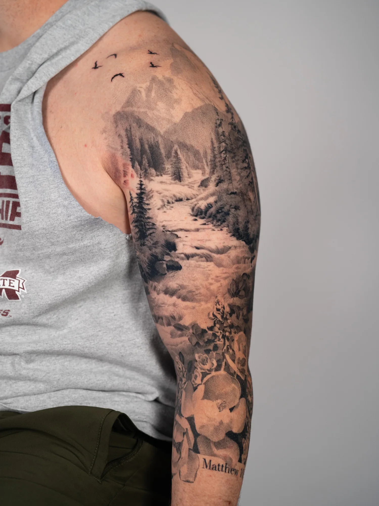 Full sleeve tattoo of a landscape in black and grey realism.