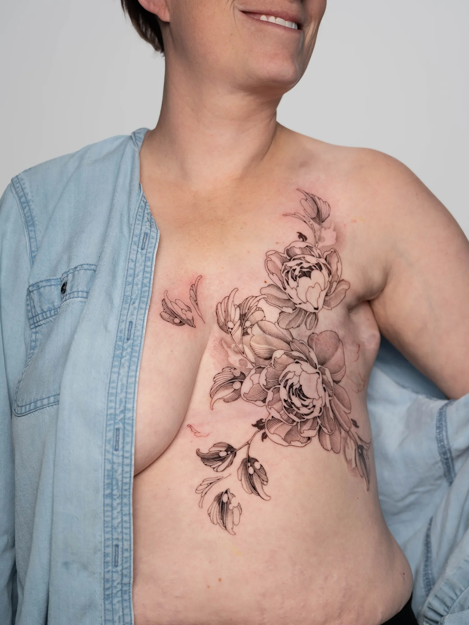 Fineline floral tattoos over a mastectomy scar.