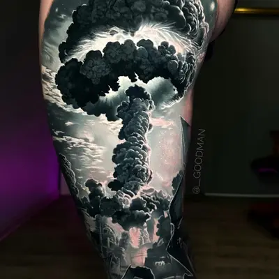 Black and grey tattoo of mushroom cloud and gas mask on thigh.