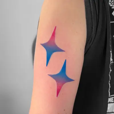 Two star-shaped tattoos with blue and pink gradient coloring on the upper arm.
