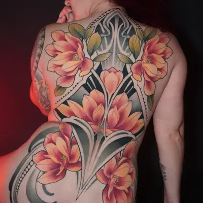 A vibrant floral and ornamental tattoo covering the entire back with bold colors and patterns.
