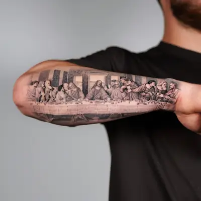Black and grey tattoo of The Last Supper on forearm.