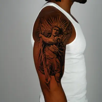 Detailed tattoo of an angelic figure of Saint Michael the Archangel, done as a half sleeve.