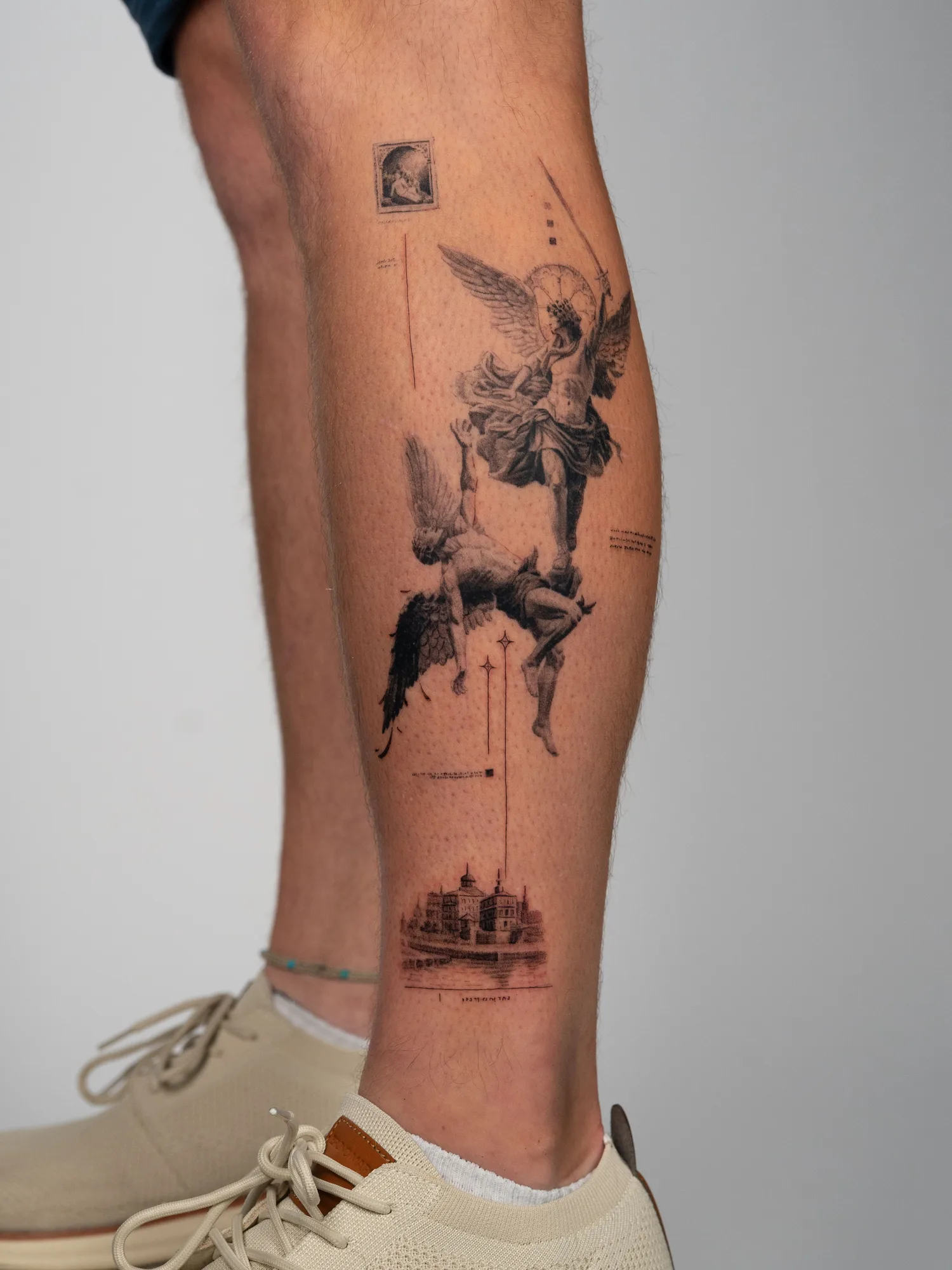 Tattoo featuring an angelic figure with a sword and architectural sketch on calf.