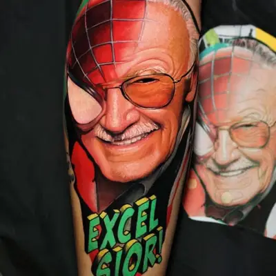 Tattoo of a man's face with Spider-Man mask and 'Excelsior!' text.