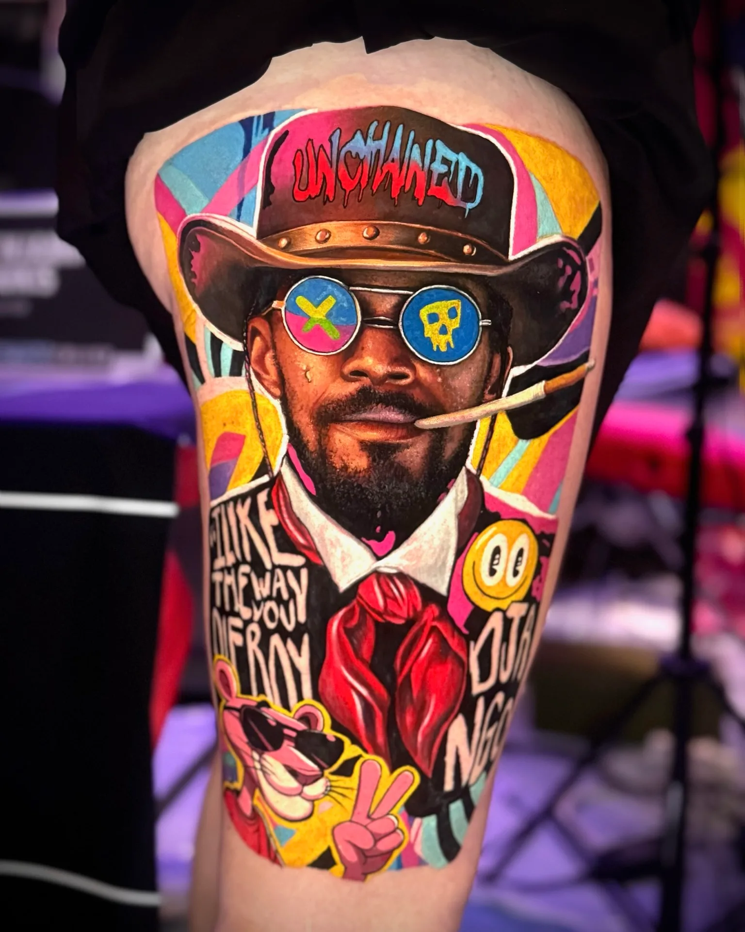 Colorful portrait tattoo with cowboy, sunglasses, and cartoon character.