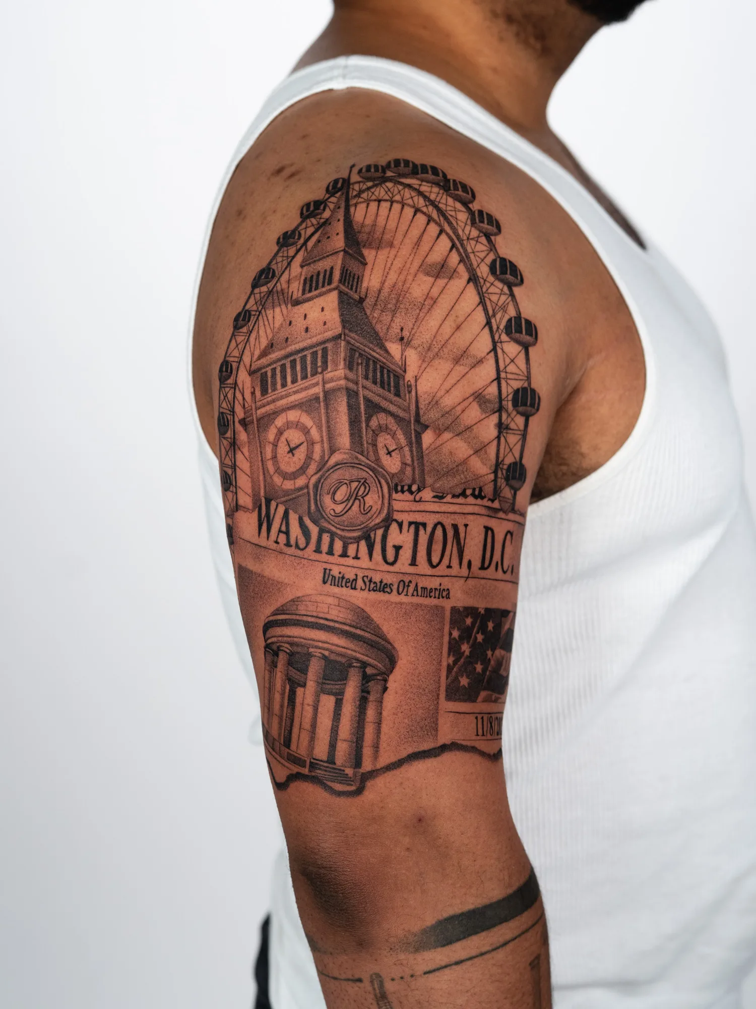 Tattoo of Big Ben and US landmarks on a man's arm.