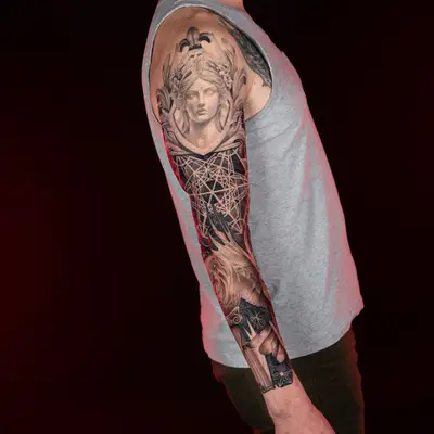 Black and grey sleeve tattoo with a classical bust and geometric design.