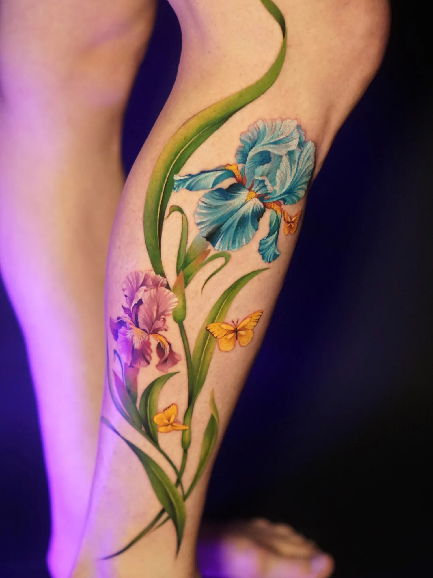 Colorful floral tattoo with butterflies on leg