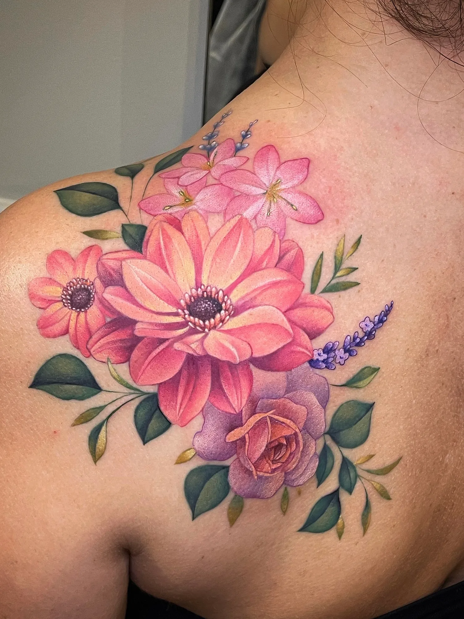 Colorful floral tattoo on shoulder with pink and purple flowers