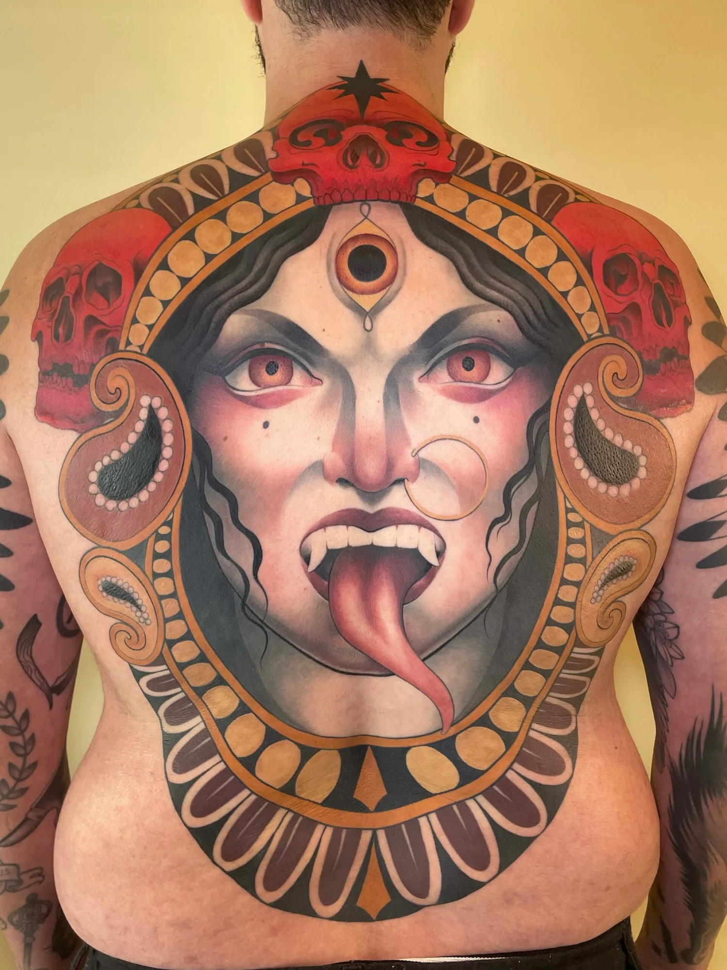 Large back tattoo featuring Kali with skulls and ornate design.