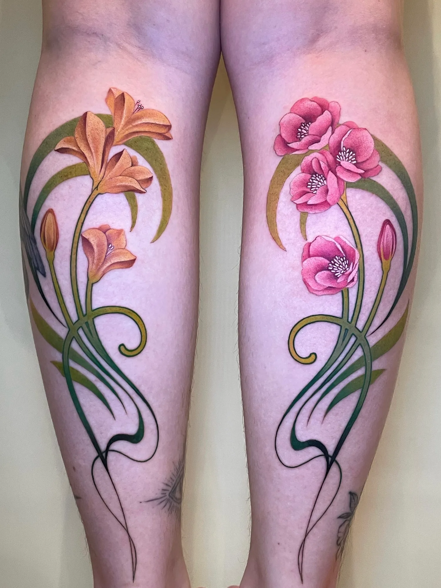 Colorful floral tattoo with lilies and poppies on calf.