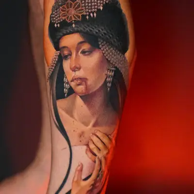 Tattoo of a woman with ornate headpiece on leg
