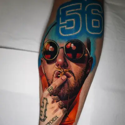 Tattoo of a man with sunglasses and number 56 on forearm.