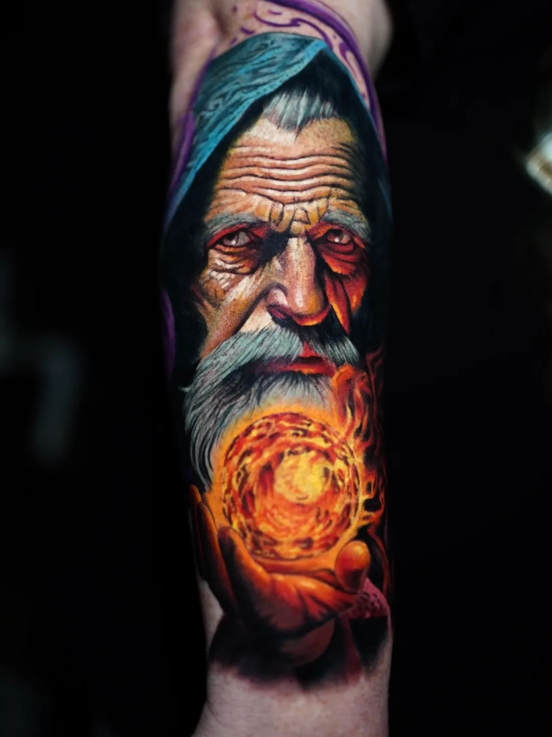 Colorful wizard tattoo holding a glowing orb