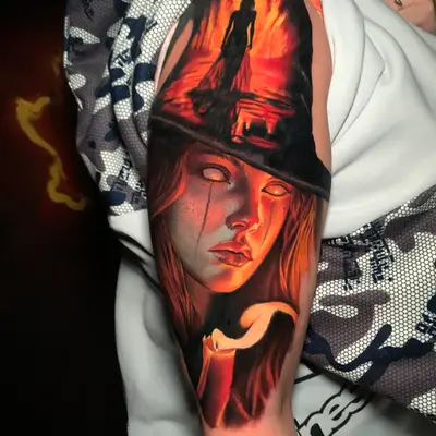 Tattoo of a woman's face and silhouette in flames on the upper arm.