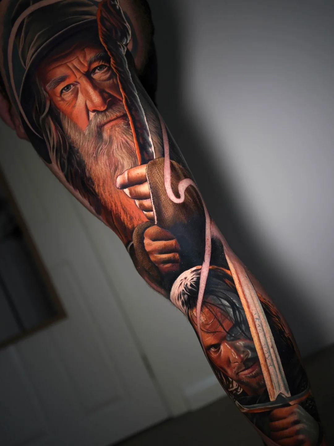 Realistic portrait tattoo of two characters holding weapons.