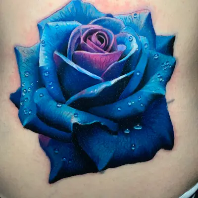 Realistic tattoo of a blue rose with water droplets.