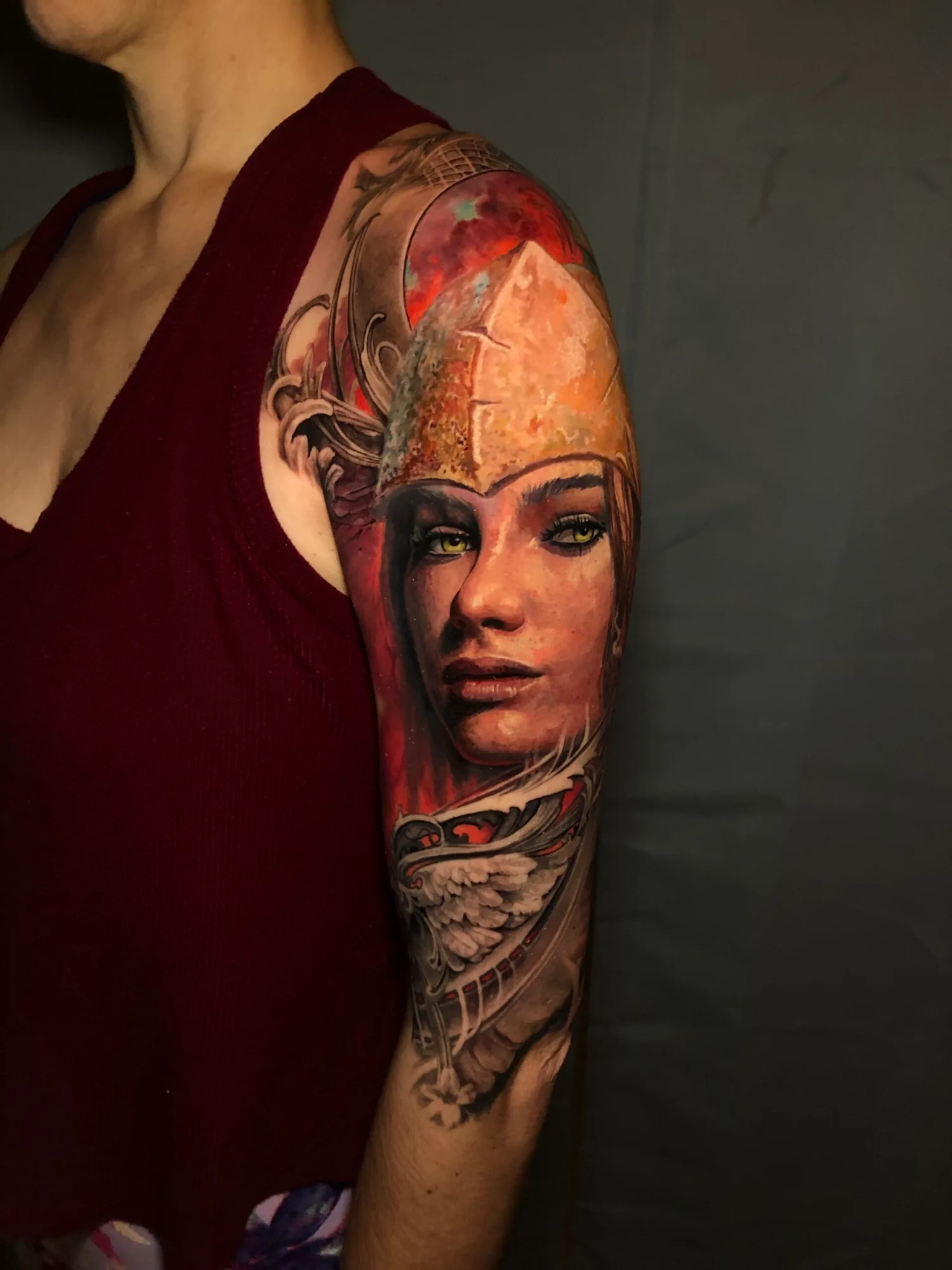 Realistic tattoo of a woman in armor, upper arm placement.