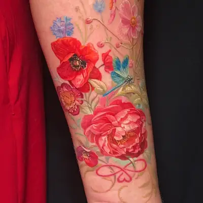 Colorful floral tattoo with dragonfly on forearm