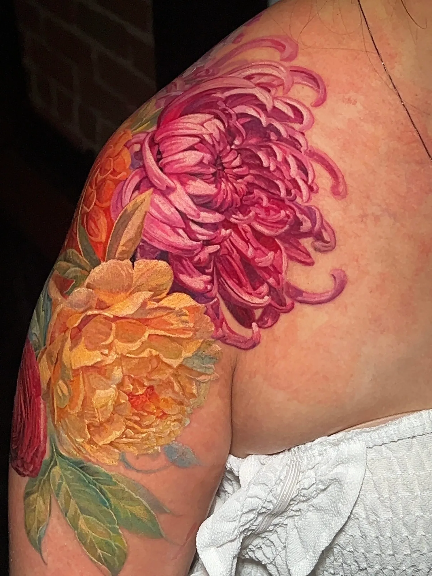Colorful floral tattoo on shoulder.