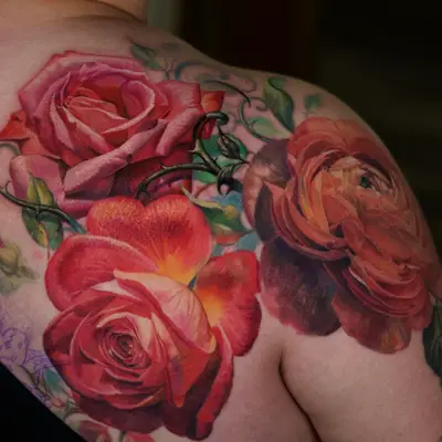 Realistic floral tattoo with roses on shoulder