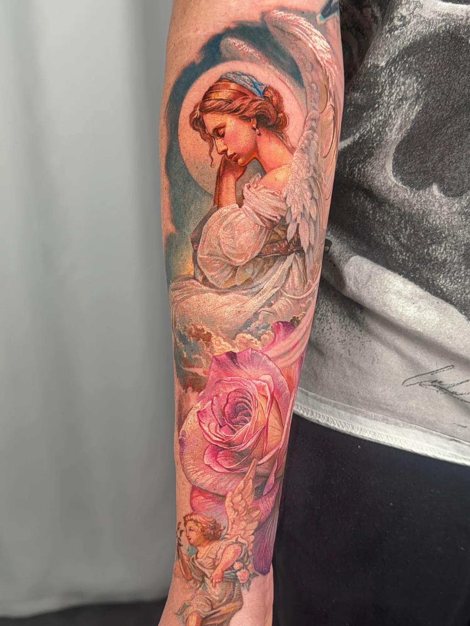 Tattoo of an angel and rose on forearm