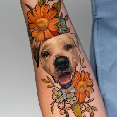 Tattoo of dog surrounded by colorful flowers on forearm.
