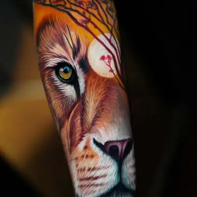 Tattoo of a lion with a sunset and tree silhouette