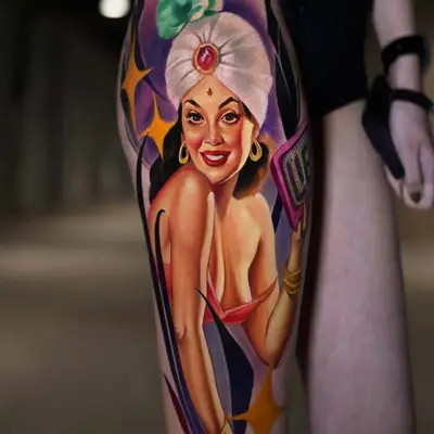 Colorful tattoo of a woman wearing a turban on a person's thigh.