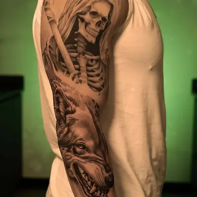 Tattoo of a reaper and wolf on a man's arm