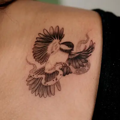 Fine line tattoo of a bird with geometric elements on shoulder.