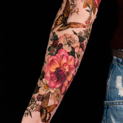 Colorful floral and butterfly tattoo on forearm