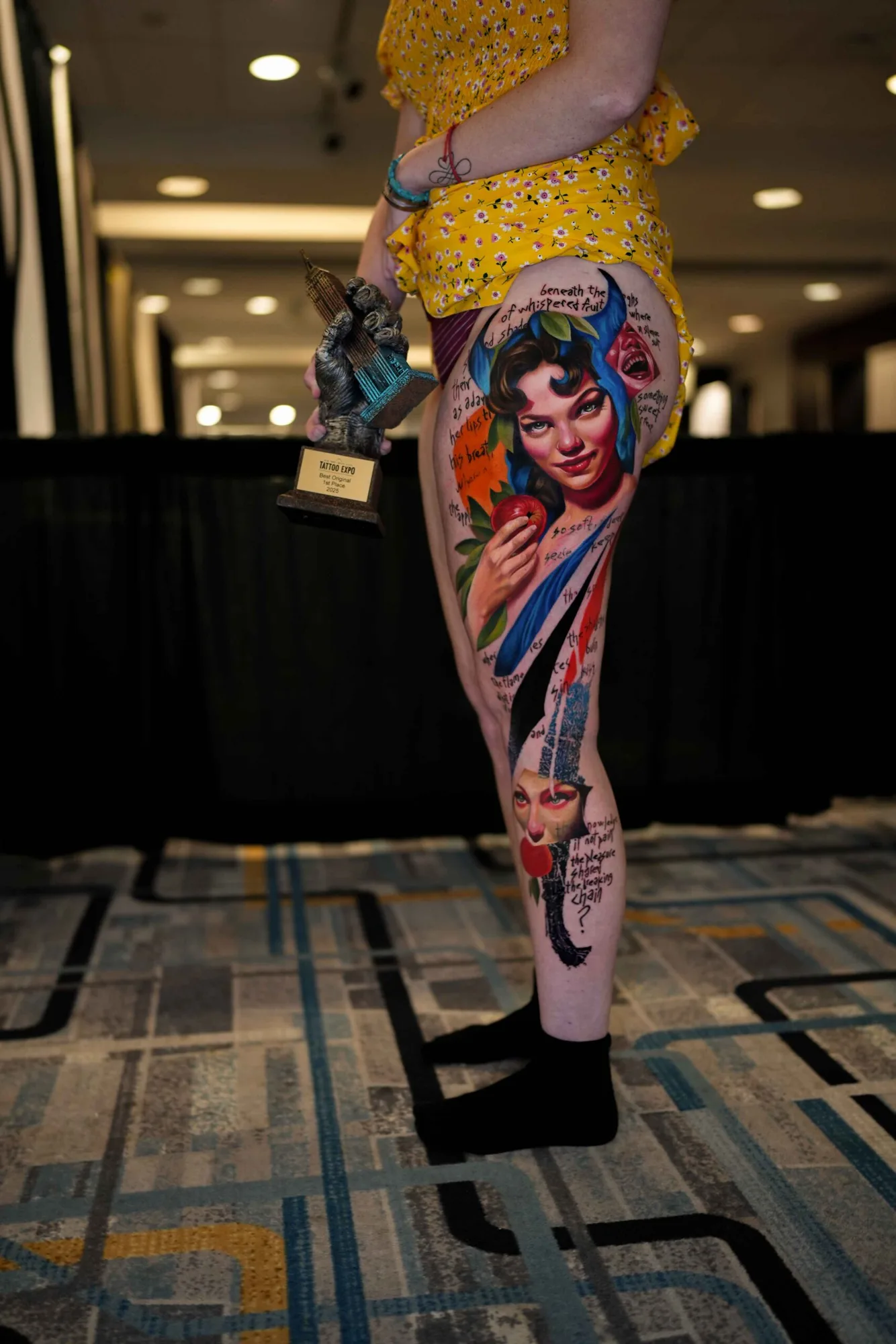Colorful tattoo on leg with woman's face and apple.